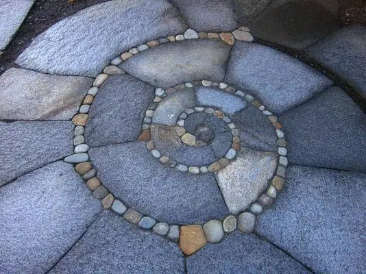 A spiral of pebbles inlaid in a stone-look floor