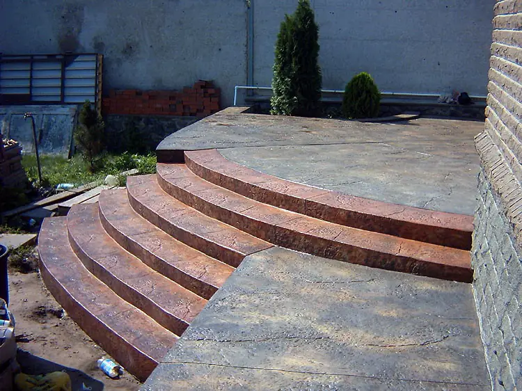 Curved entrance steps in red-brown stamped concrete