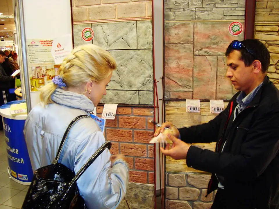 A visitor and an exhibitor in front of the sample panels