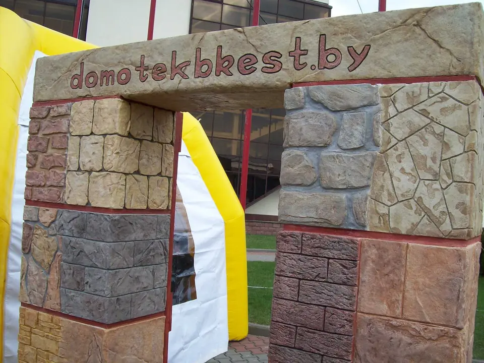 A gateway arch built of textured stone blocks in different colours