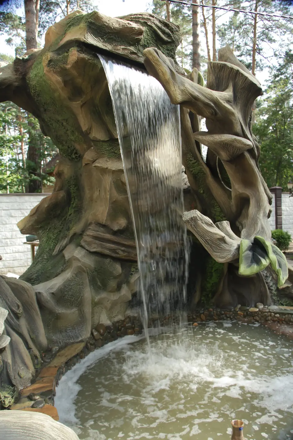 Water falling through a sculpted tree-trunk fountain