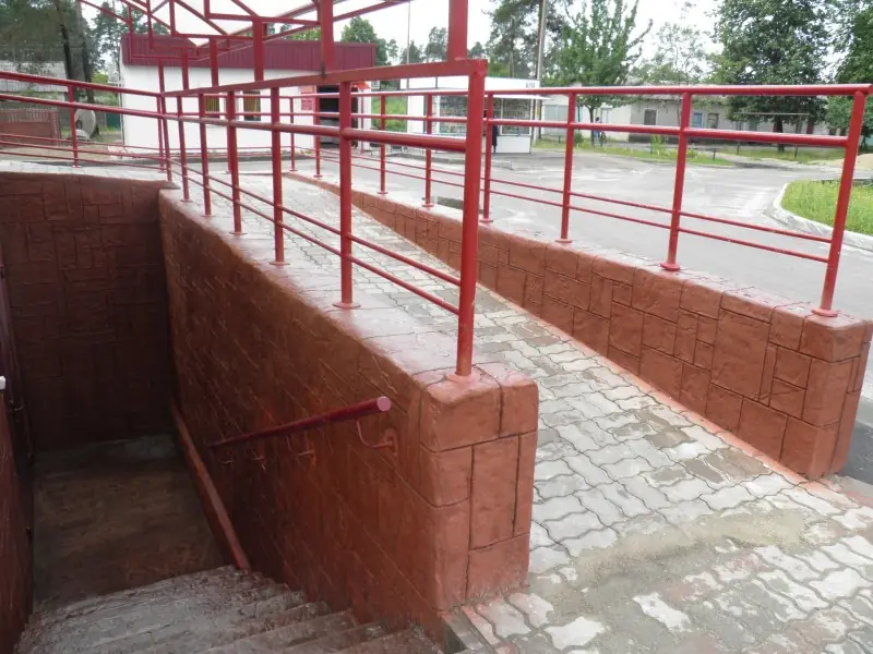 Retaining wall and ramp with red railings