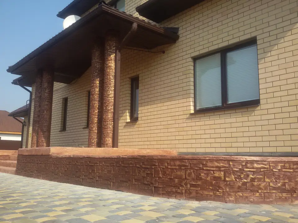 Porch columns modelled as tree trunks above a stone-effect plinth