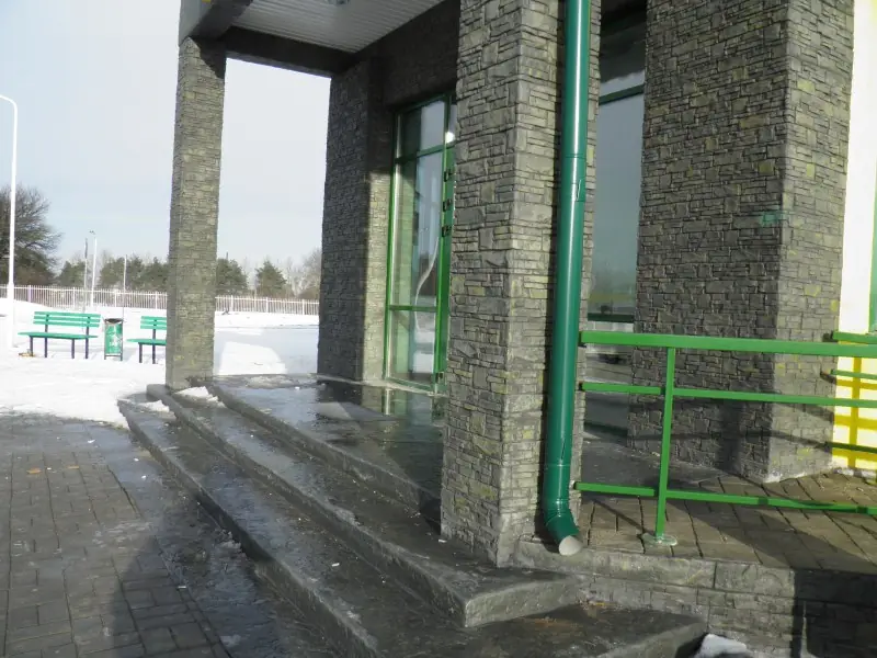 Stone-clad columns and wide steps at the shop entrance in winter