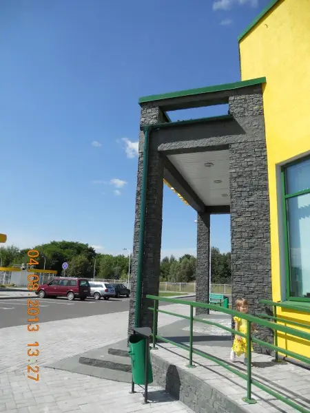 The portal seen from the side, with green railings along the steps
