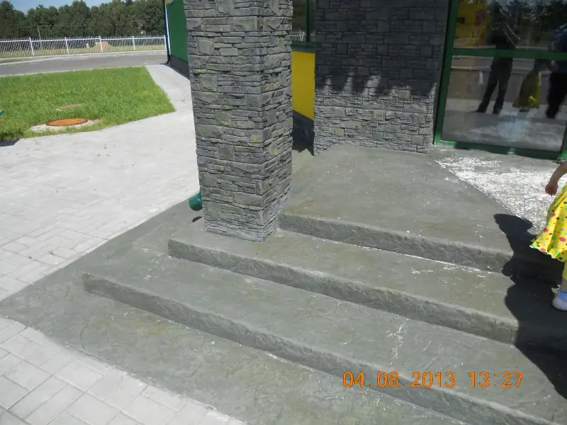 Base of a stone-clad column and the textured concrete steps