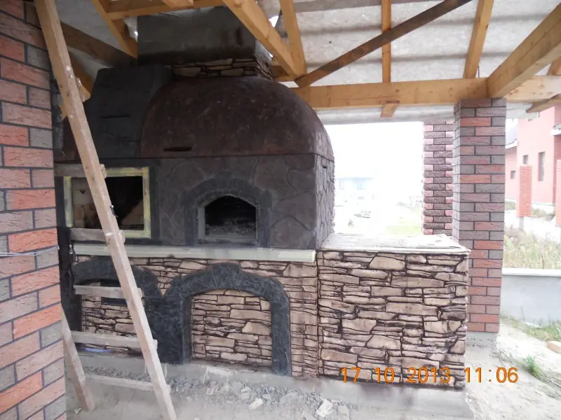 Large brick oven with an arched stone base in an open pavilion