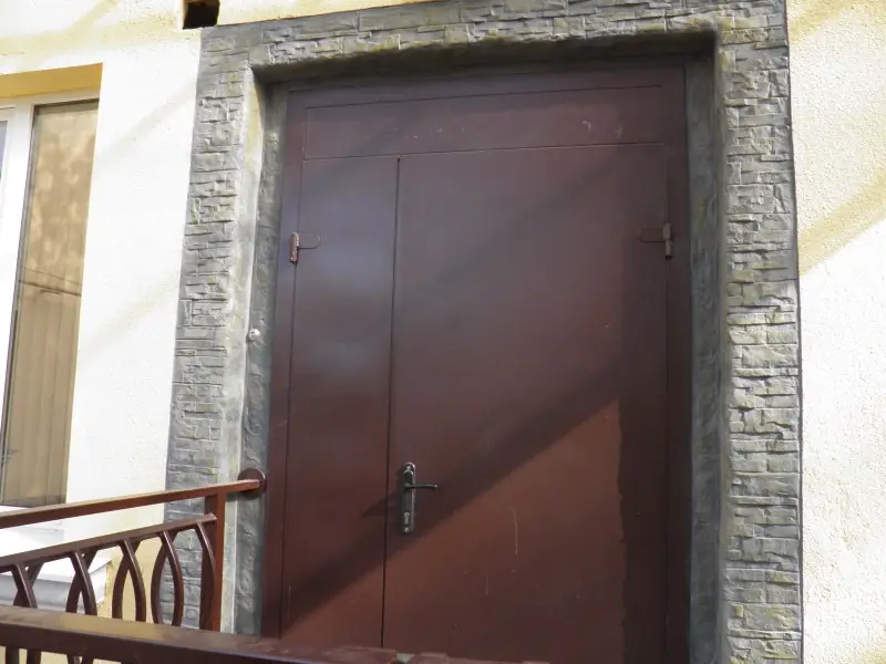 Close-up of a door frame faced in rough stone-effect