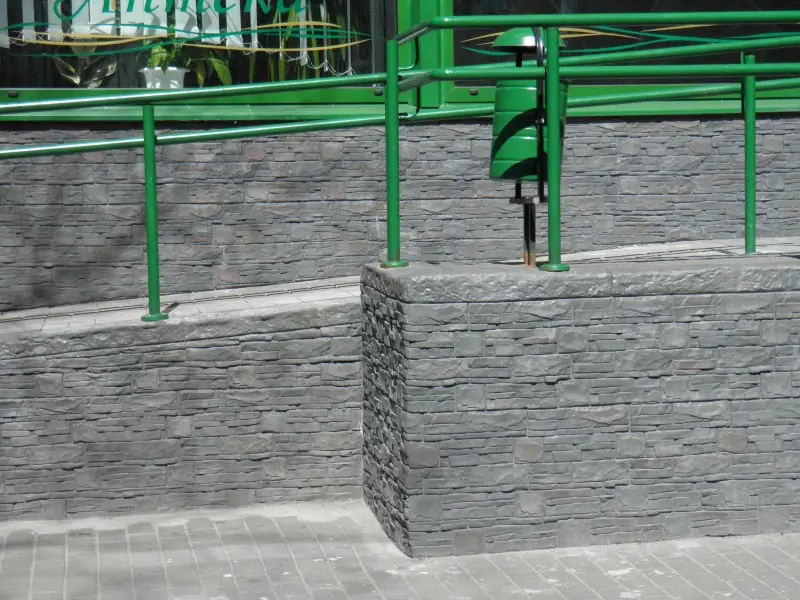 Stone-faced wall and landing beside green railings