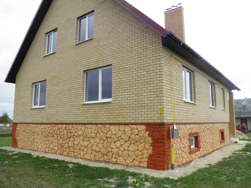 House on a plinth of pale flagstone pattern with rust-red edging