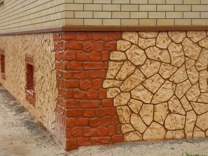 Corner of the plinth where the flagstone pattern meets an orange cobble-effect surface
