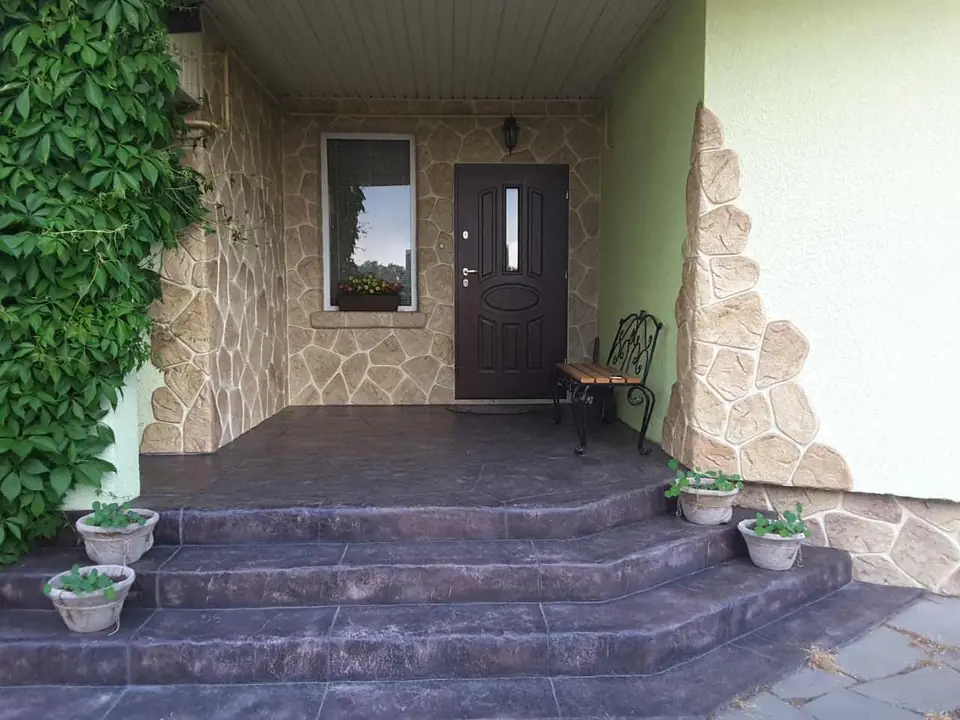 Porch with stamped-concrete steps and a stone-clad wall