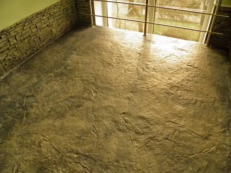 Stone-textured floor in golden tones beside a glazed wall