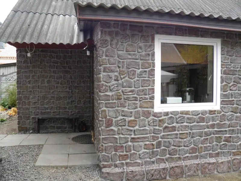 Side wall with a window and a bench under the eaves