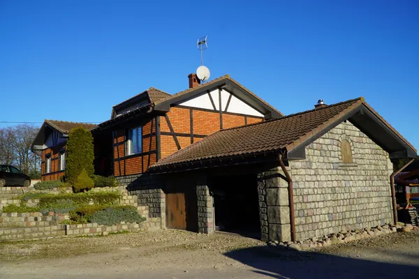 Das ganze Haus: das Fachwerk-Hauptgebäude und der steinverkleidete Anbau mit Garage