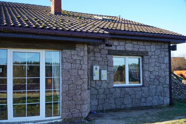 Terrassentüren und Zählerschränke, in die Steinwand eingelassen