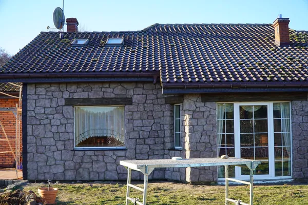 Die Gartenfassade näher: Fenster, Terrassentüren und Steinpfeiler