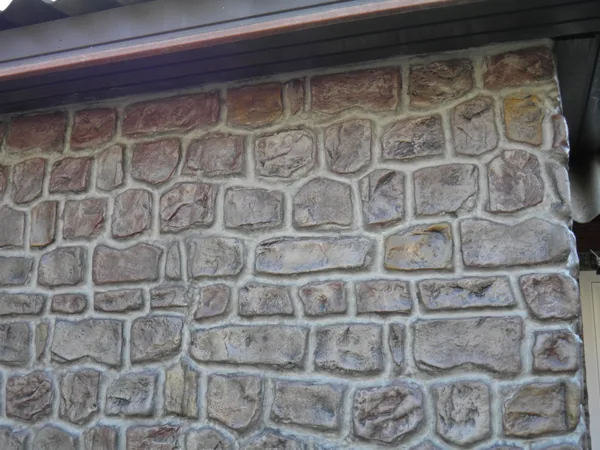 Close-up below the eaves: rounded stones and light joints