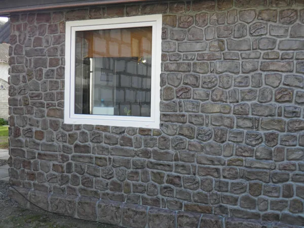 Side wall with a window above a row of large plinth stones