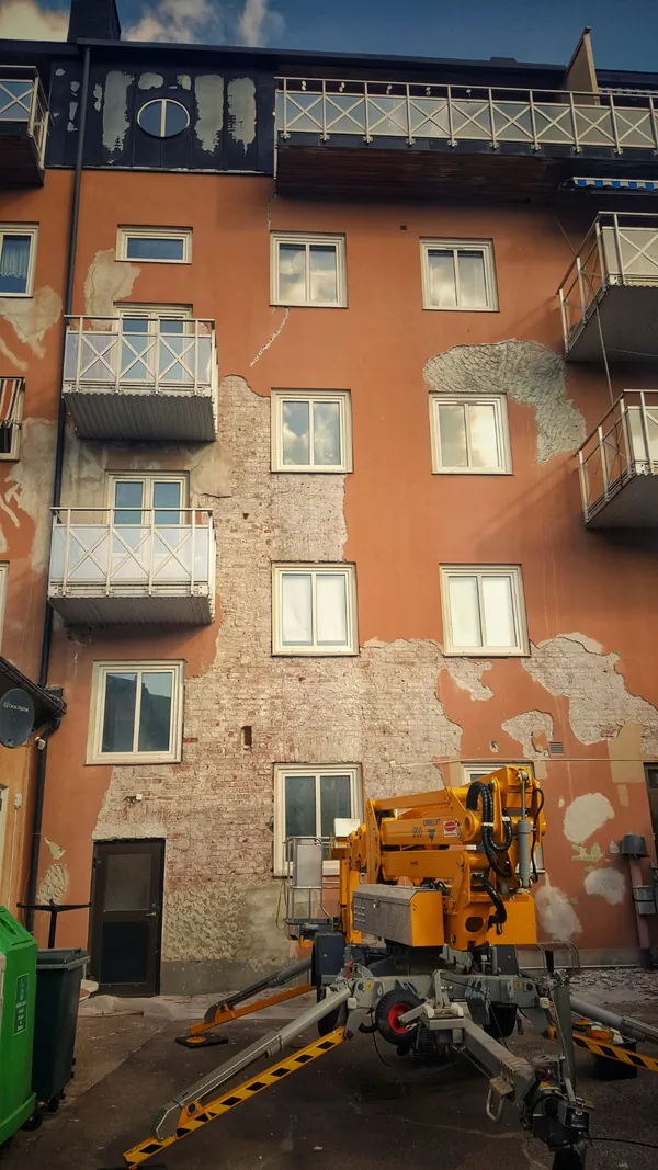 Fachada del patio antes de las obras: revoco antiguo retirado hasta el ladrillo en grandes zonas
