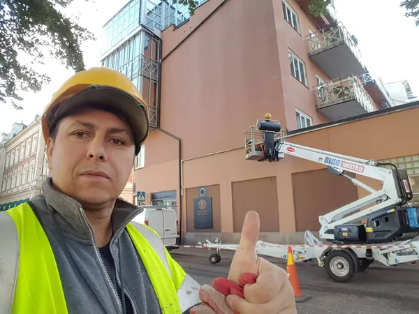 Aleks Svirydzenka en la obra de Kristinehamn, con la fachada terminada detrás