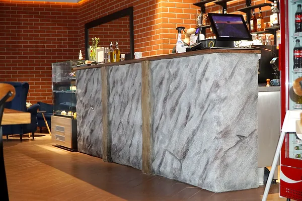 The counter from the side: deep diagonal strata and broken stone edges