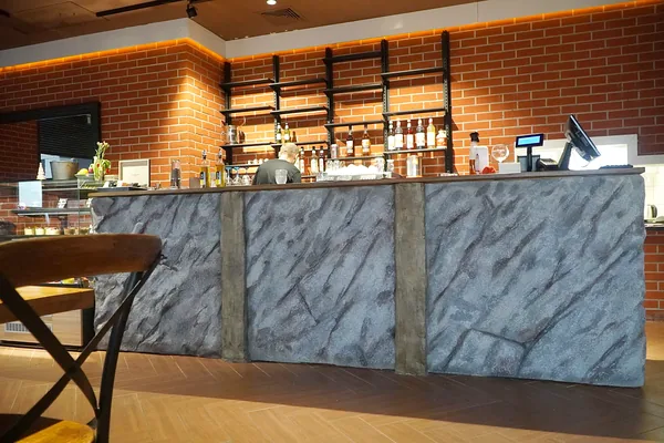 Bar counter in artificial slate-grey rock with two timber-look posts
