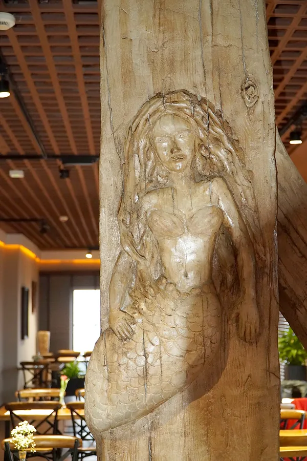 Mermaid relief carved into the timber column
