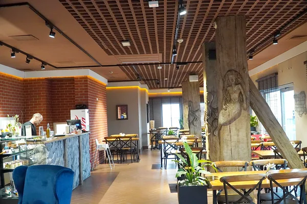 The café hall: bar counter on the left, relief columns on the right