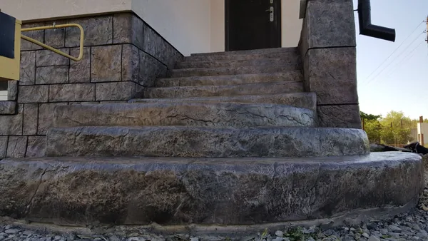 The entrance stair from below: curved stone steps leading to the door