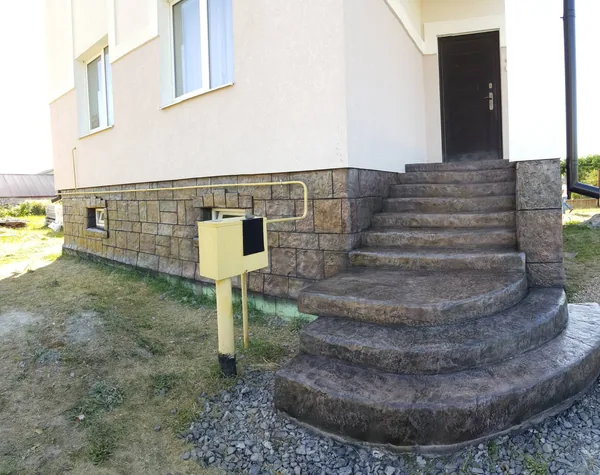 The stair together with the stone plinth of the house
