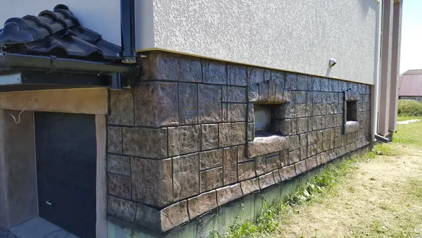 Basement windows framed by stepped stone surrounds