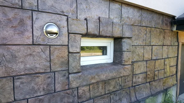 Close-up: stone blocks, a vent and a window surround