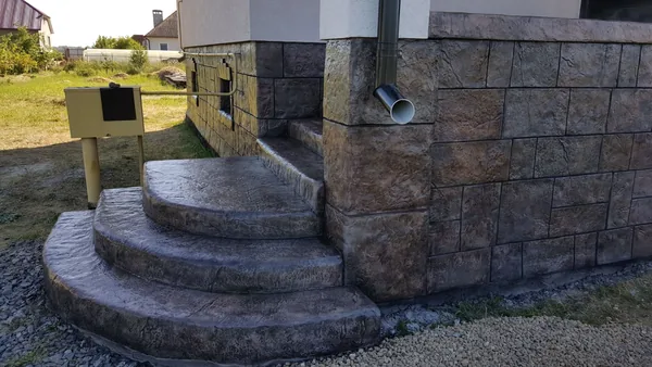 Curved steps and the stone pillar at the corner of the terrace