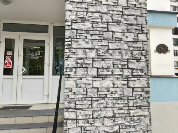 Close-up of a pillar: thin layered stone, white with graphite shadows