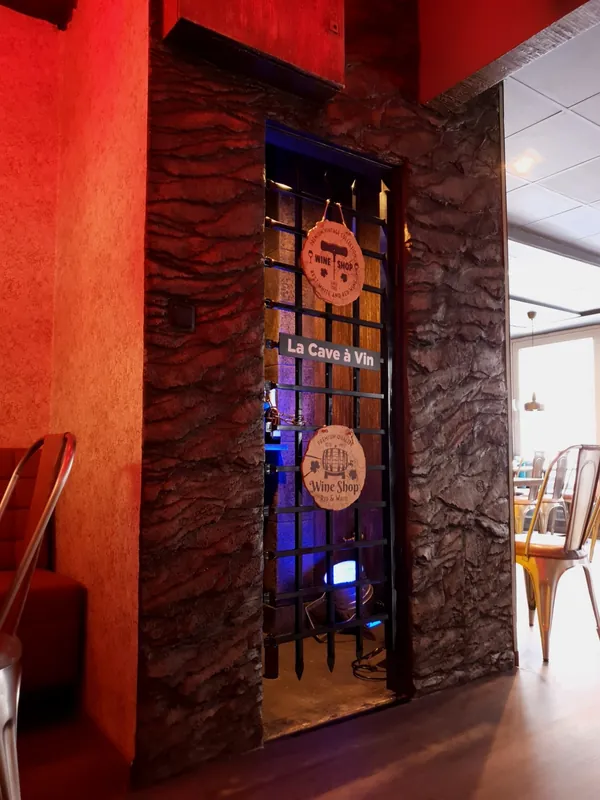 La Cave à Vin: البوابة الحديدية في جدار من صخر صناعي متعدد الطبقات