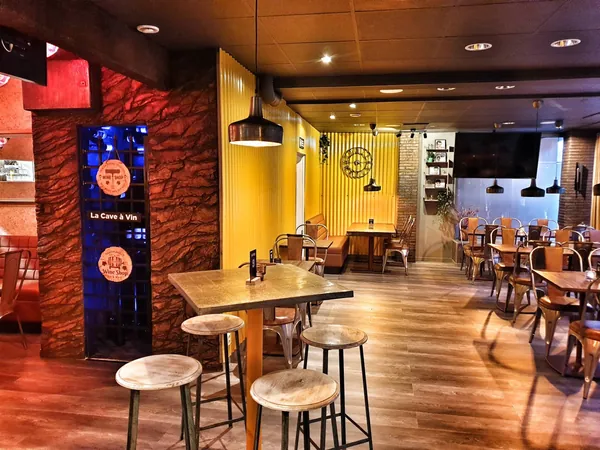 La Cave à Vin بجانب الجدار المموّج الأصفر وقاعة الطعام