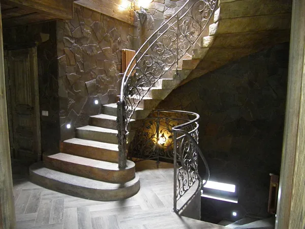 The staircase seen from the doorway, with lights set into the stone wall