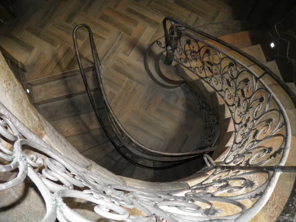 From the top landing: the curve of the stone flight down to the herringbone floor