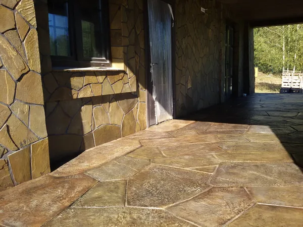 Floor and wall together: irregular flagstones running up to the window and the door