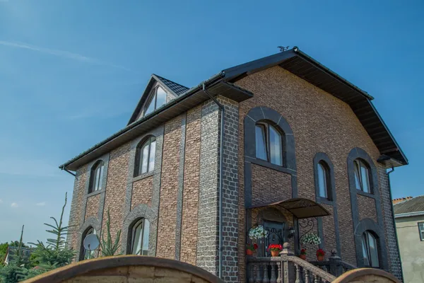 Huset från trädgårdssidan under en blå himmel